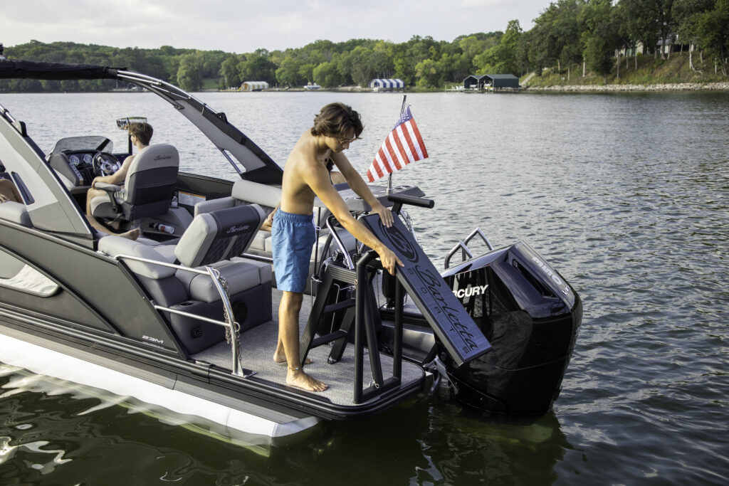 Teen moving LilliPad Diving Board into upright position on Barletta Pontoon Boat.